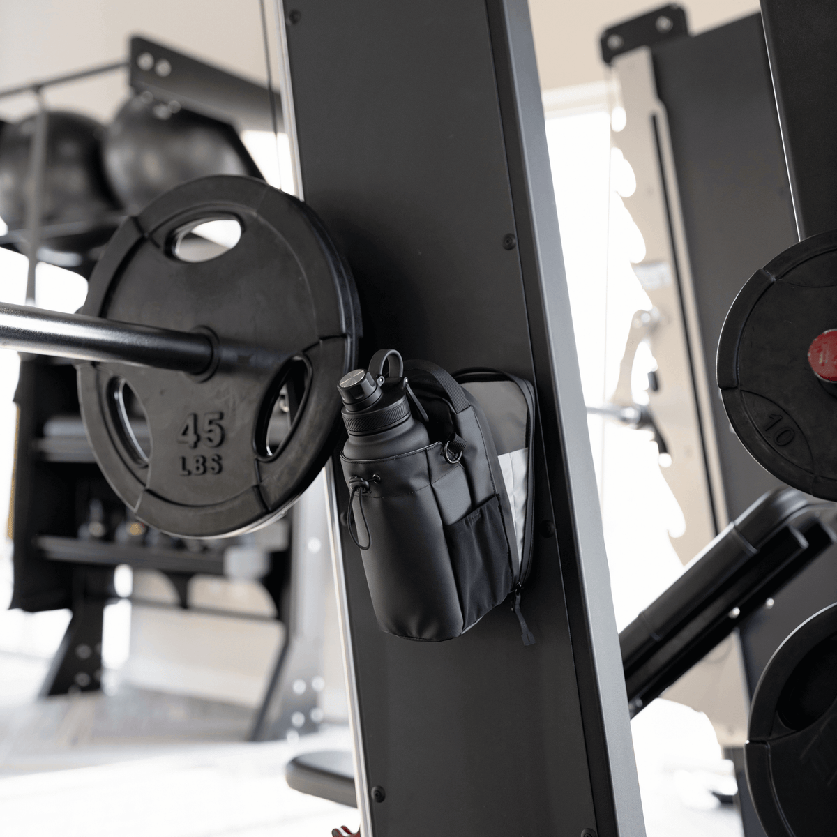 Titan Gym Bag by HolyH₂O™ attached to gym equipment, showcasing its magnetic gym bag feature for convenience.